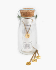 Bottled golden Zodiac symbol necklace on delicate chain.  Packaged in a 4" tall glass bottle with cork stopper.  The Zodiac sign necklace is the perfect ready-to-go gift! Handmade in Frisco TX, Julio Designs